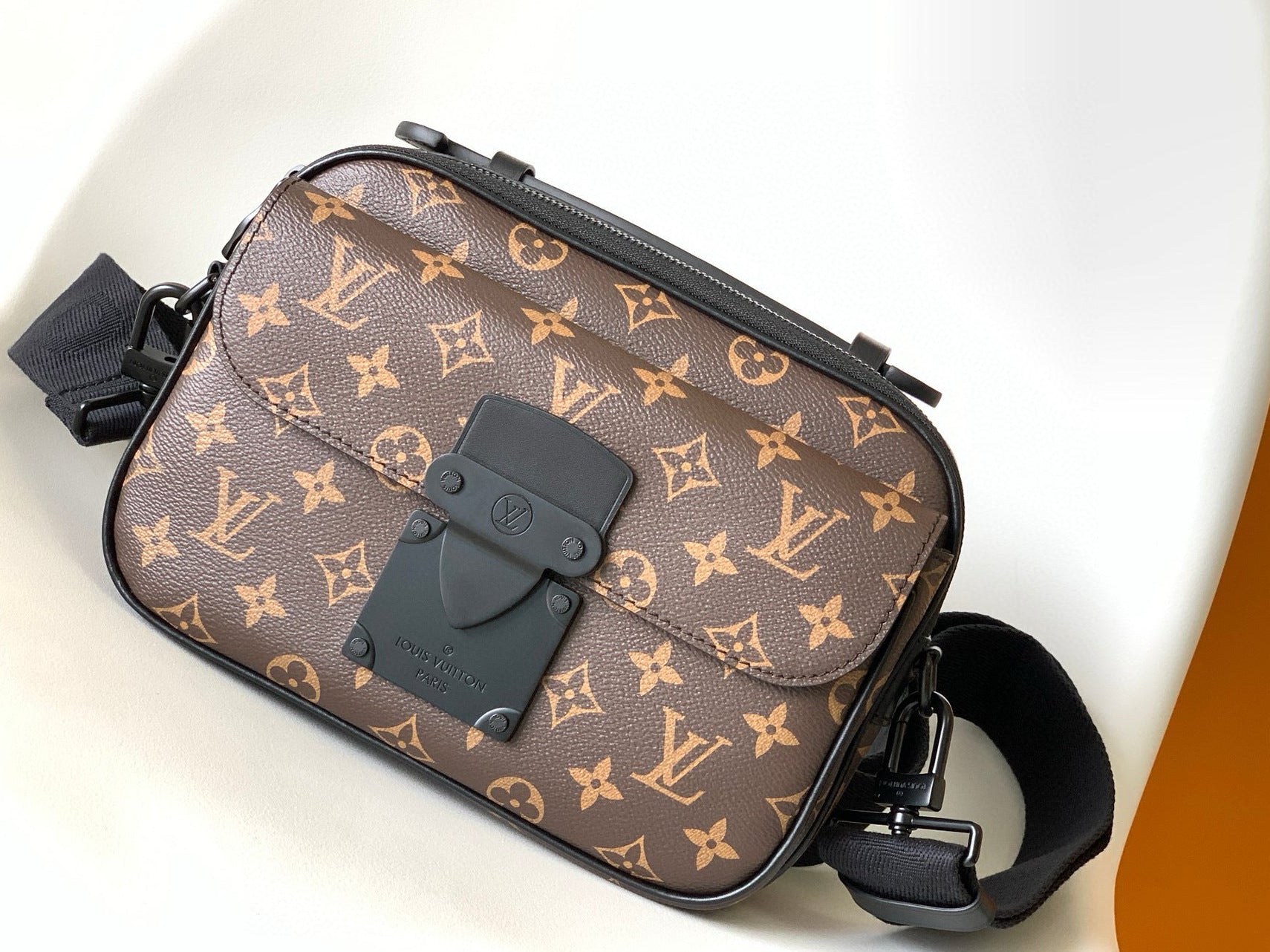 Designer handbag with monogram pattern on a white surface