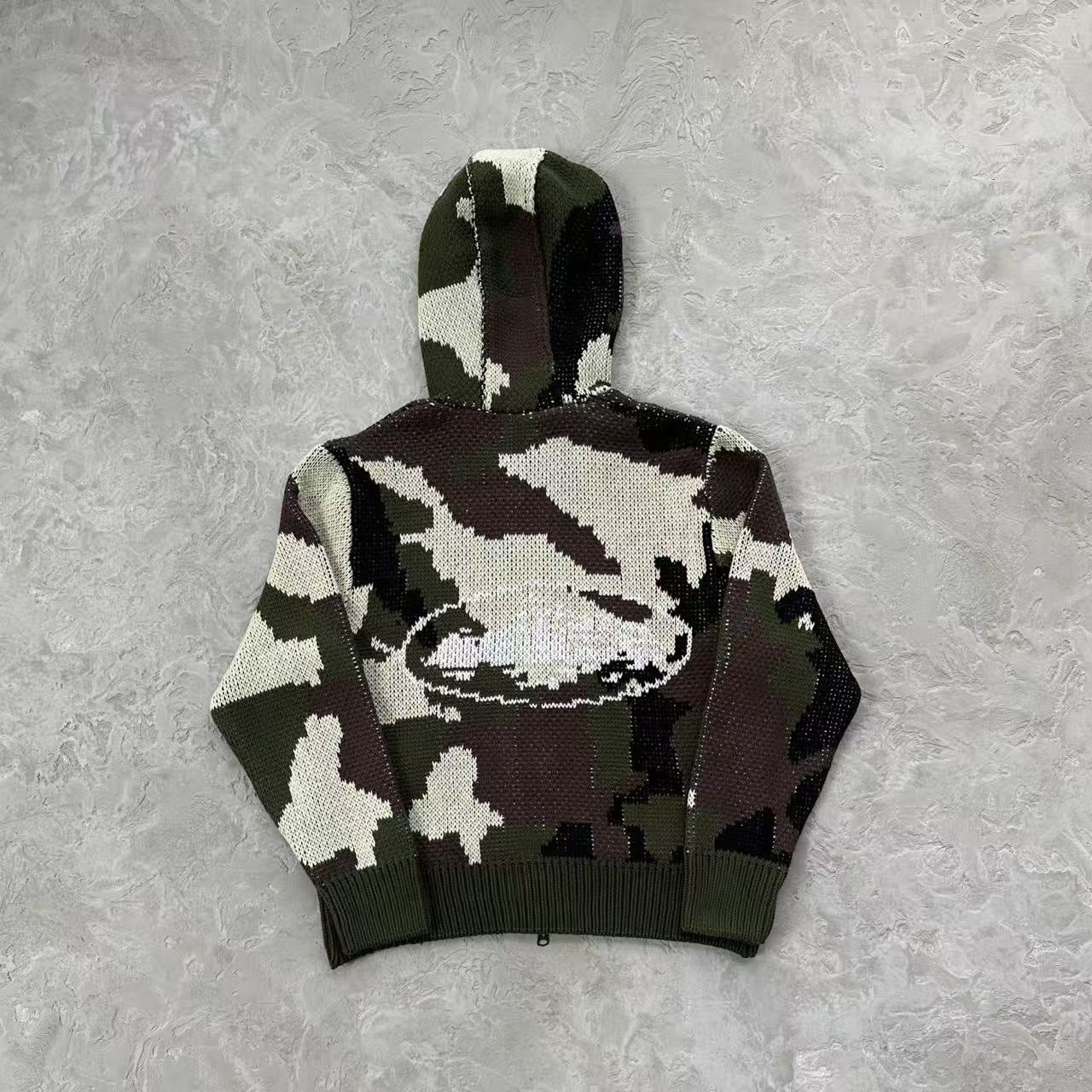 Camouflage-patterned hoodie on a textured gray background