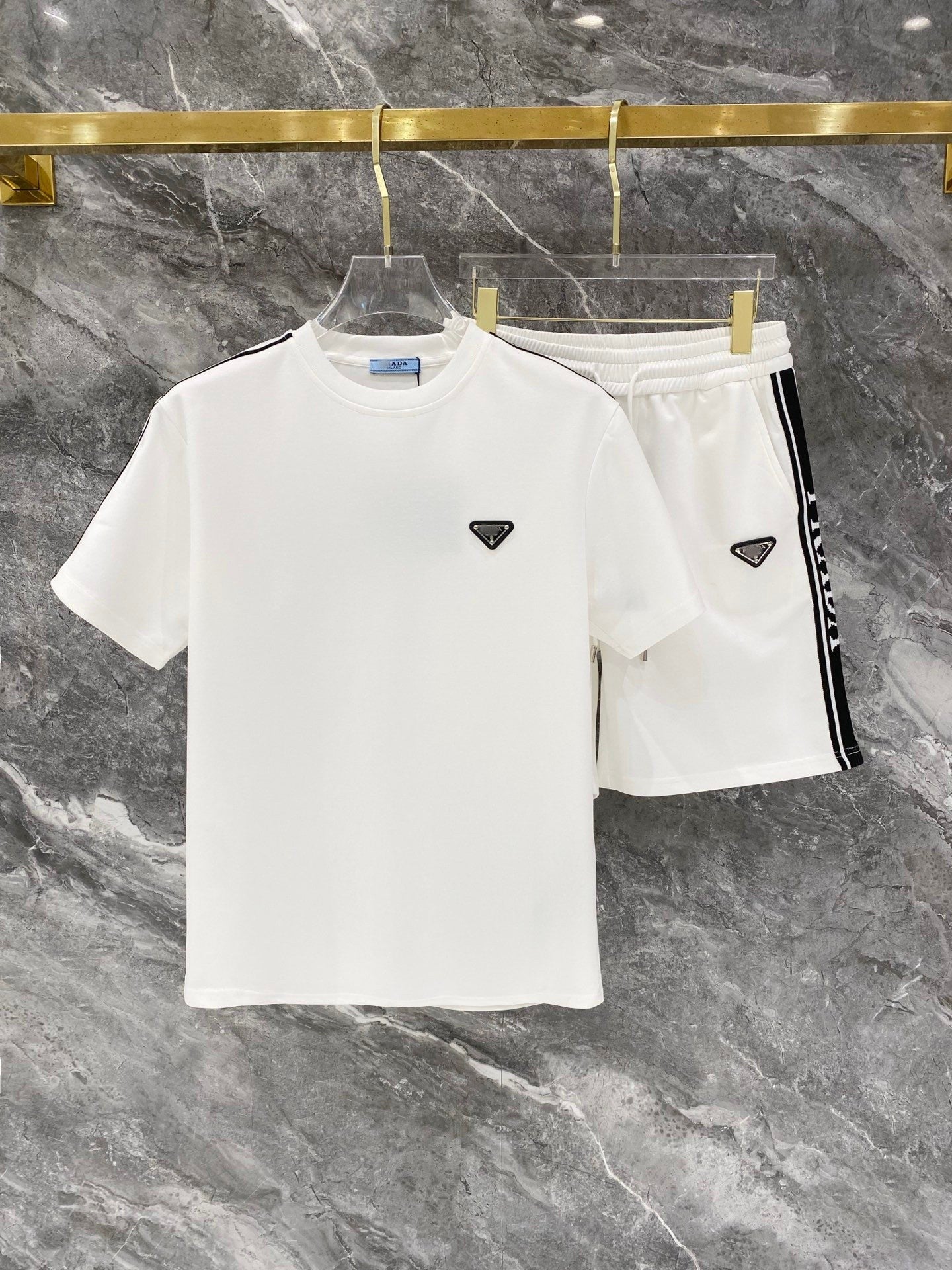 White t-shirt and shorts set with a logo on a marble surface