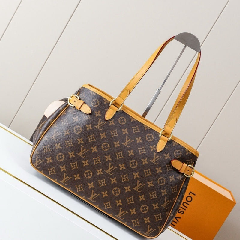 Louis Vuitton monogram canvas handbag in brown with tan leather handles and trim, displayed on a white surface with a Louis Vuitton box partially visible behind it.