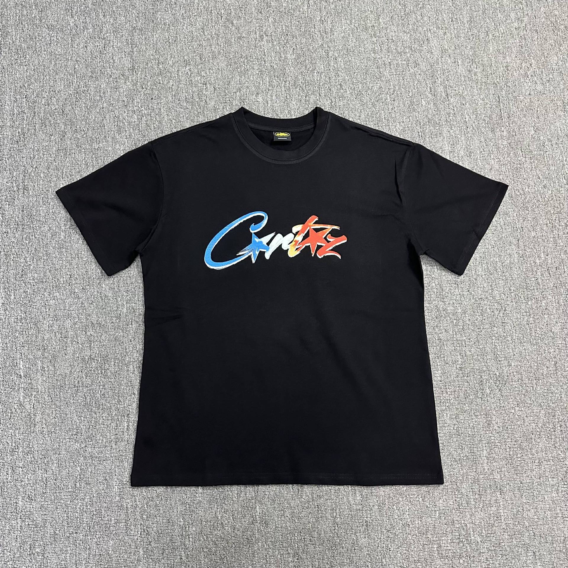 Black t-shirt with colorful logo on a gray background