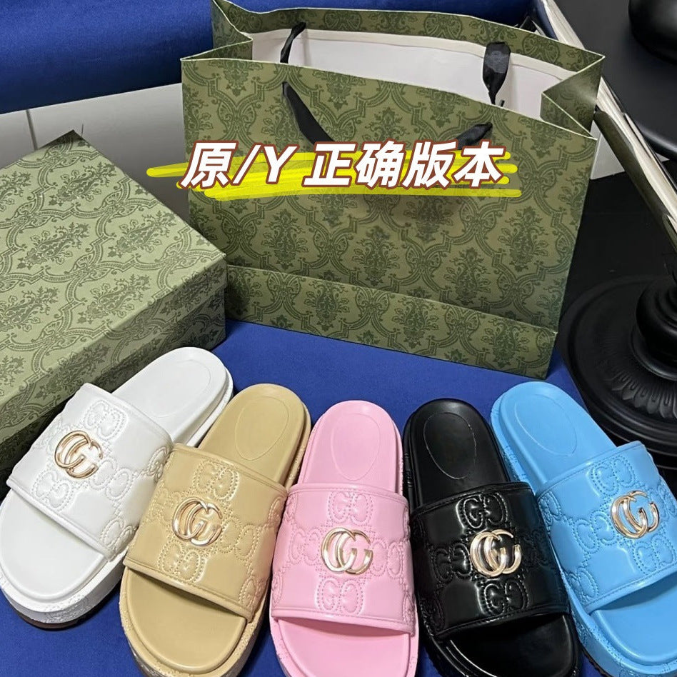 Four Gucci slide sandals in white, beige, pink, and blue, arranged in front of a green patterned shopping bag and matching box on a blue surface. A large Chinese text overlay is visible across the center.