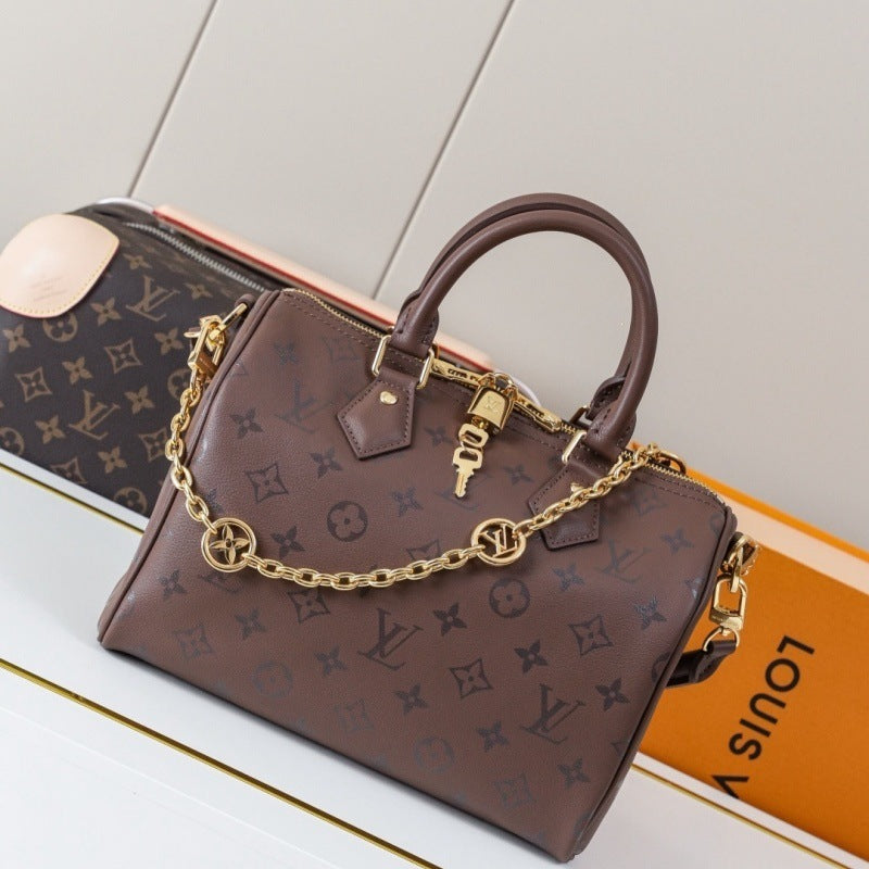 A brown Louis Vuitton monogram handbag with gold-tone chain strap and padlock detail, displayed on a white surface with a Louis Vuitton box in the background.