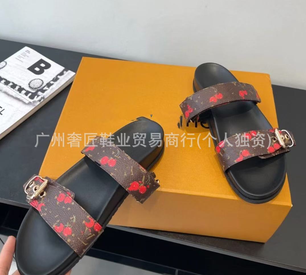 Black sandals with red floral pattern on a black surface