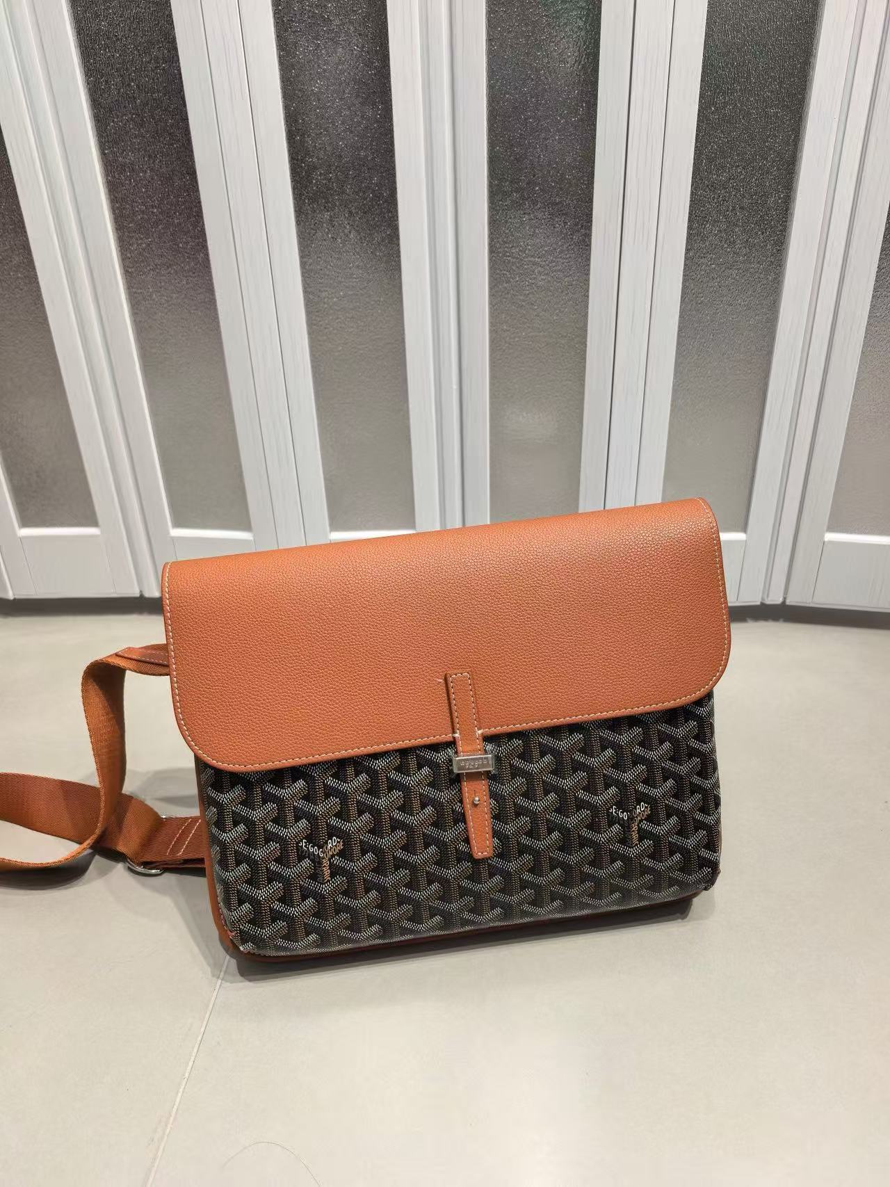 Brown and black patterned handbag on a light gray floor with a striped wall background