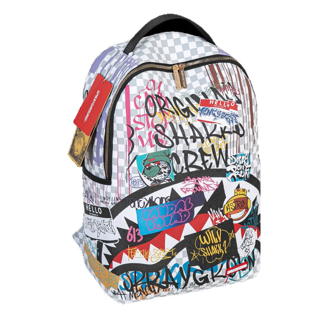 A Spray-Rite backpack featuring a white and gray checkerboard pattern base covered in colorful graffiti-style graphics, stickers, and text, including 'Original Shakyko Crew' and 'Hello Kitty'.