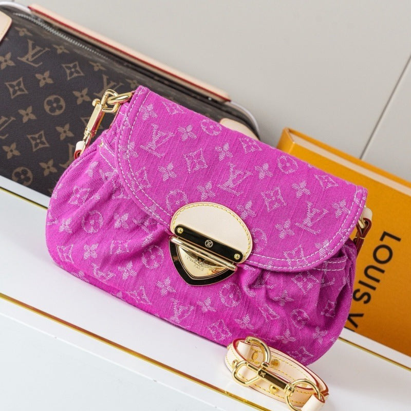 A Louis Vuitton monogram canvas shoulder bag in vibrant pink, styled on a white surface with a Louis Vuitton monogram wallet and an orange book in the background.