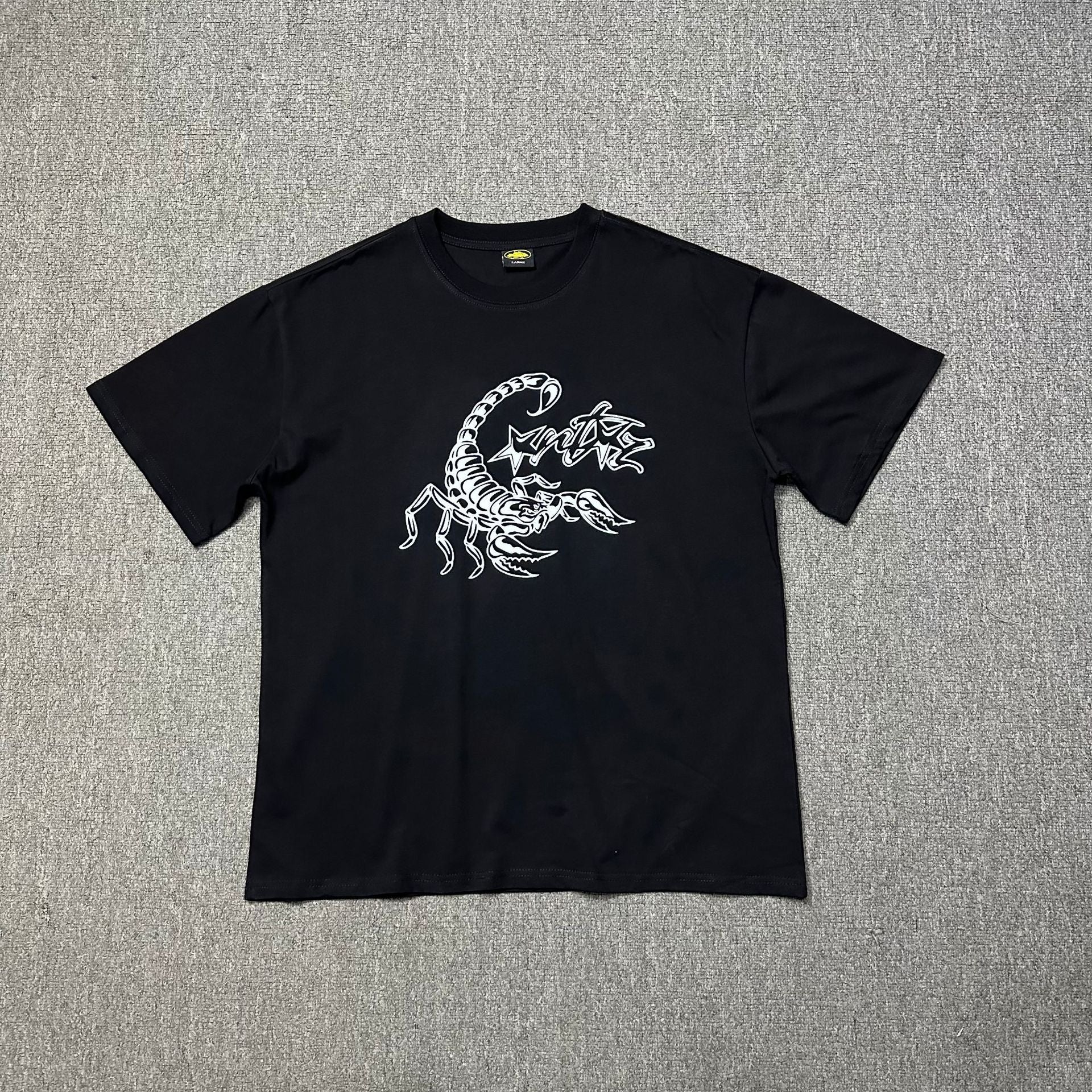 Black t-shirt with white graphic design on a gray background