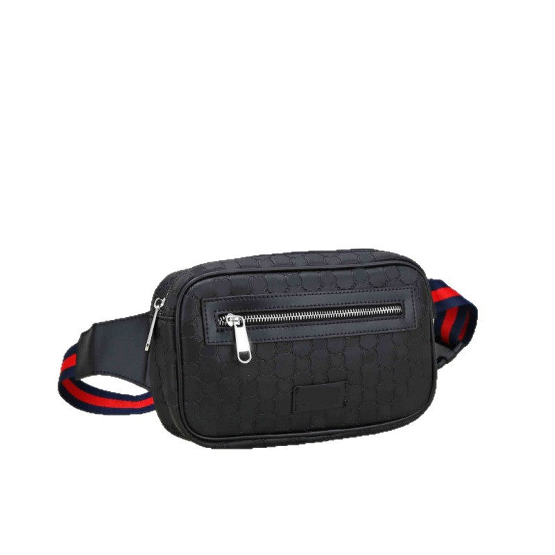 A black canvas crossbody bag with a subtle repeating monogram pattern, featuring silver zippers and a webbed strap with red and navy blue stripes.