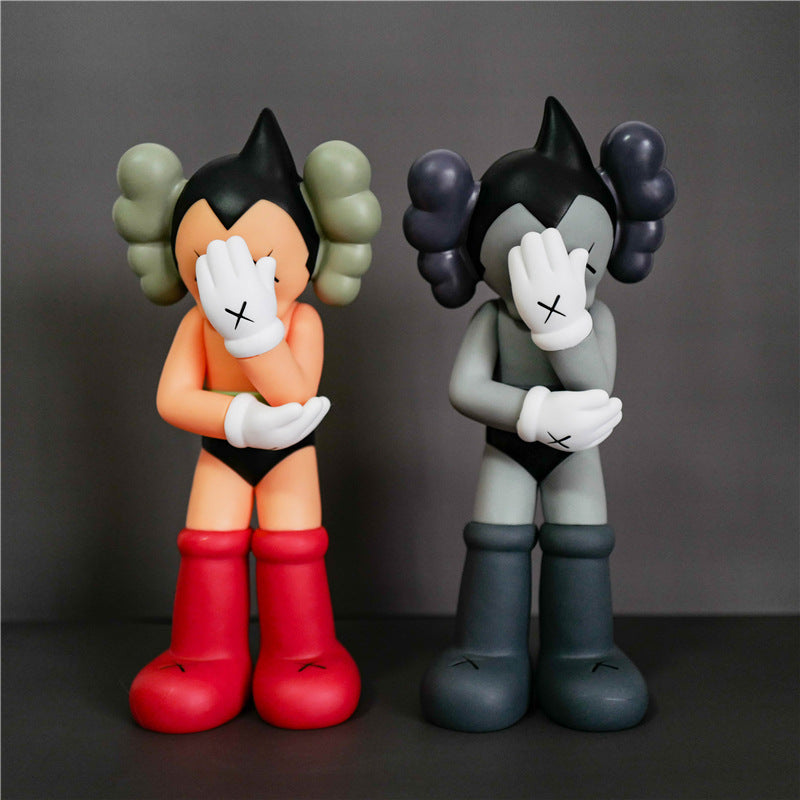 Two stylized cartoon figurines posed side by side against a dark gray studio background. The left figure has olive green hair buns, a peach face and torso, black shorts, white gloves, and red boots.