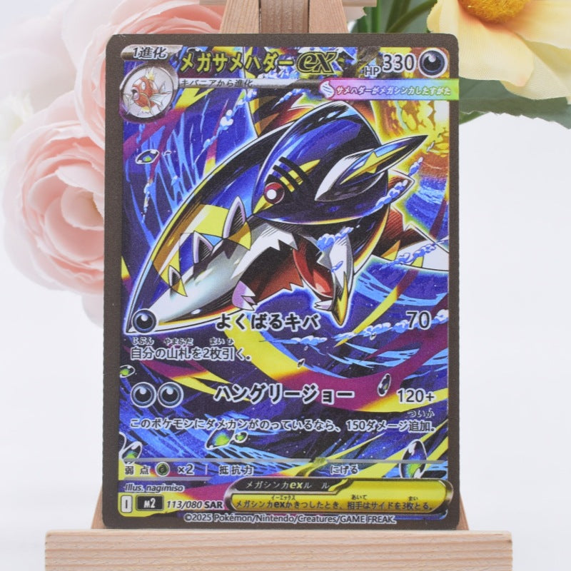 A Japanese Pokémon trading card featuring Mega Zekro, displayed on a small wooden stand against a white background with soft pink and yellow flowers in the corners.