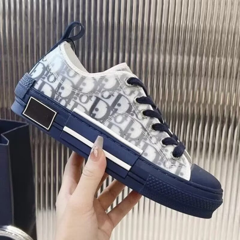 Navy and white sneaker with brand logo held by a hand against a neutral background