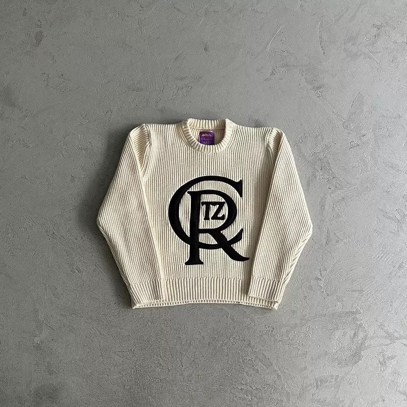 Beige sweatshirt with a logo on a gray background