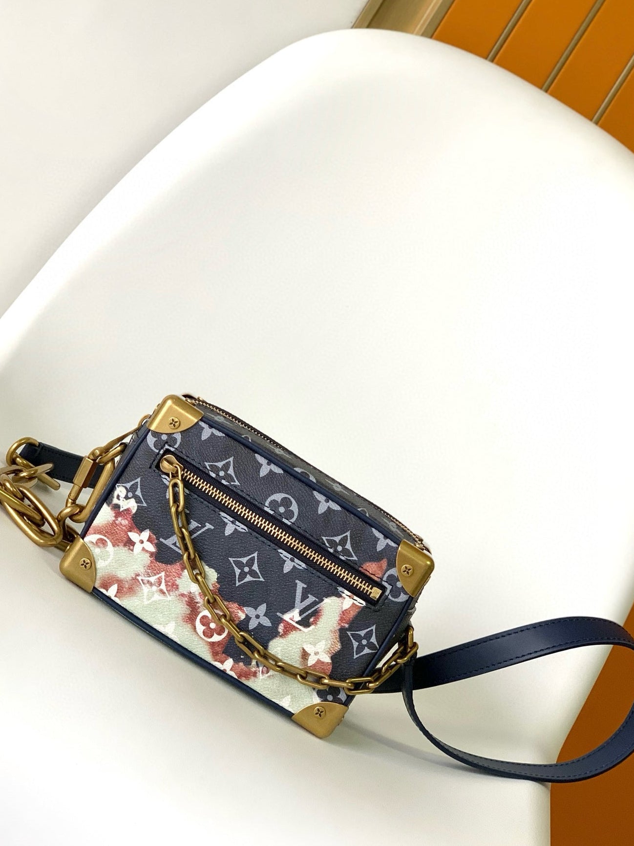 Designer handbag with floral pattern on a white surface