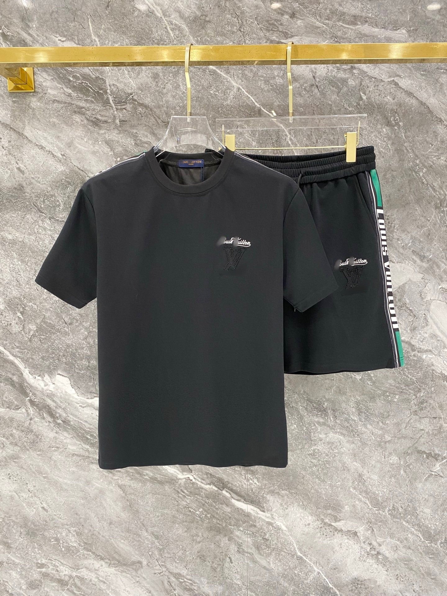 Black t-shirt and shorts set with logo on a marble surface