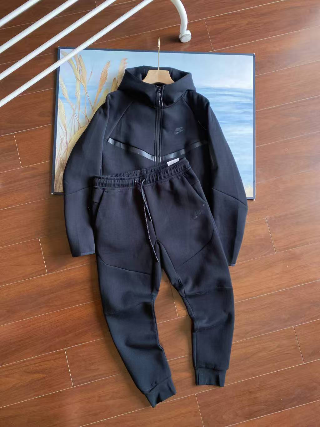 Black outfit on a hanger against a wooden floor background