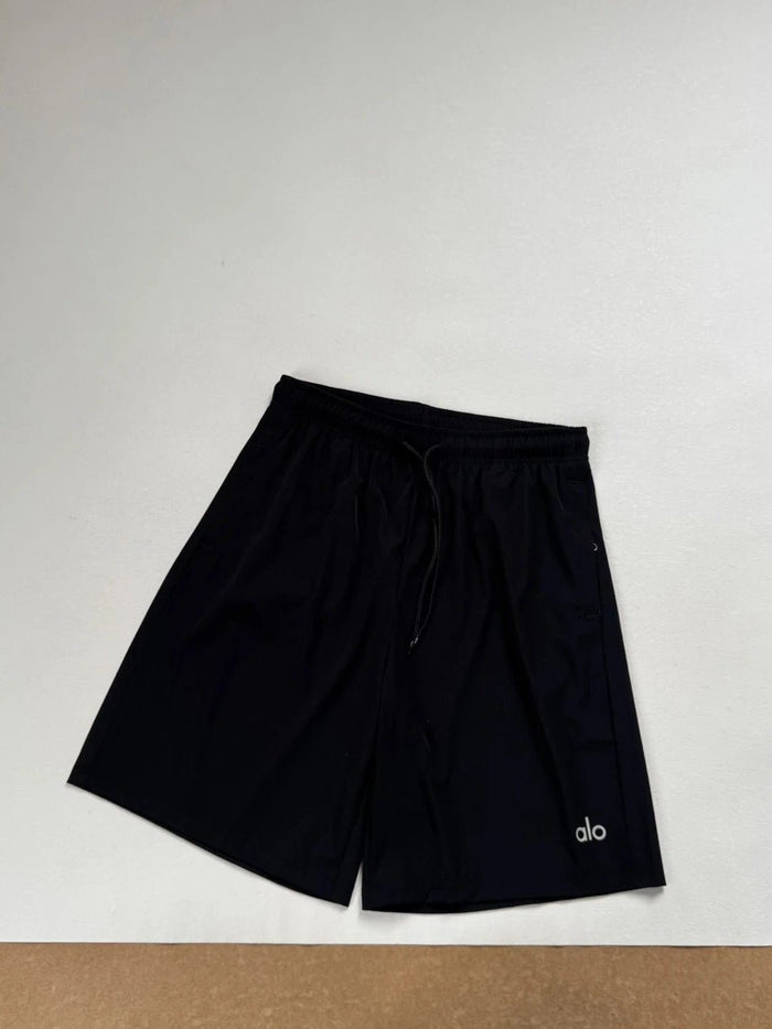 Black shorts with 'alo' branding on a light gray background