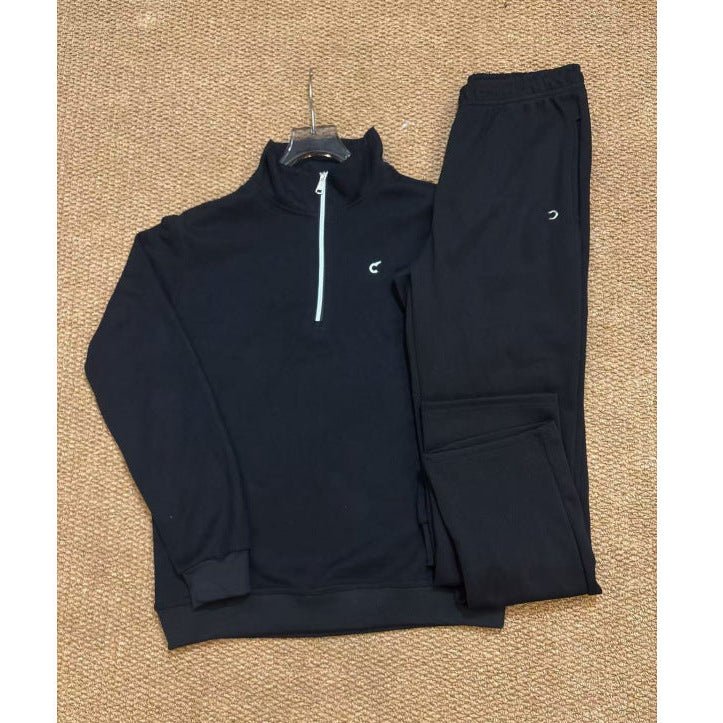 Black tracksuit laid out on a textured surface