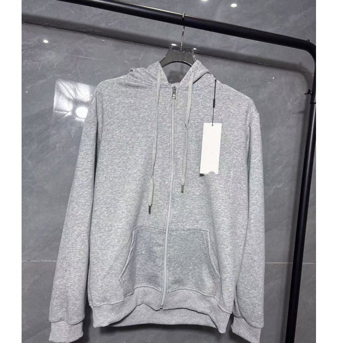 Gray hoodie with a tag on a hanger against a reflective glass wall.