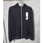 Black hoodie with a white logo tag on a gray background