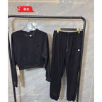 Black tracksuit on a rack against a marble wall