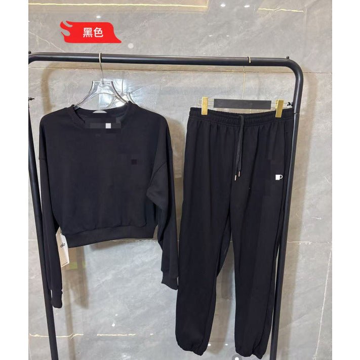 Black tracksuit on a rack against a marble wall