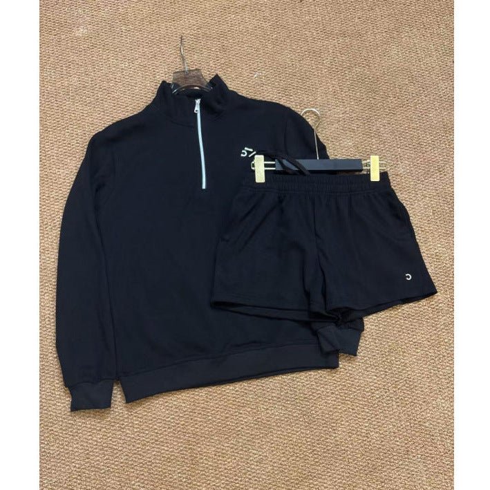 Black half-zip sweatshirt and shorts set on a beige carpet