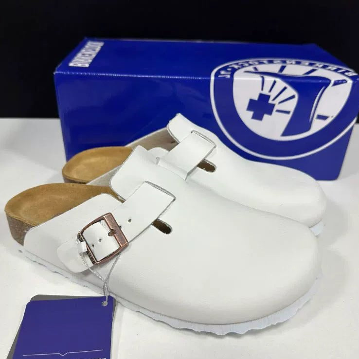 White clogs with brown insole and blue box in the background