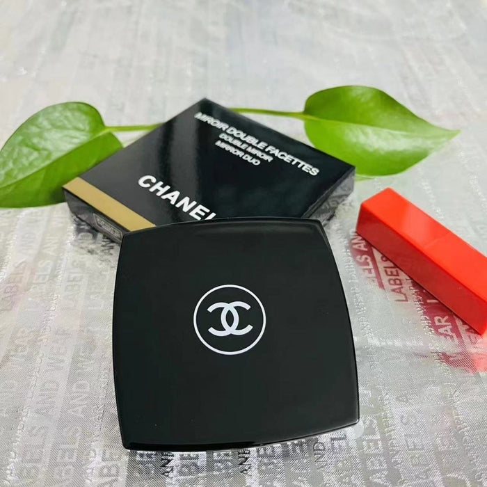 Chanel makeup compact with green leaves and a red object in the background