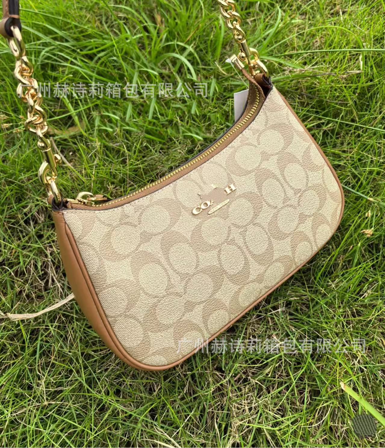 Beige handbag with brown accents on grass