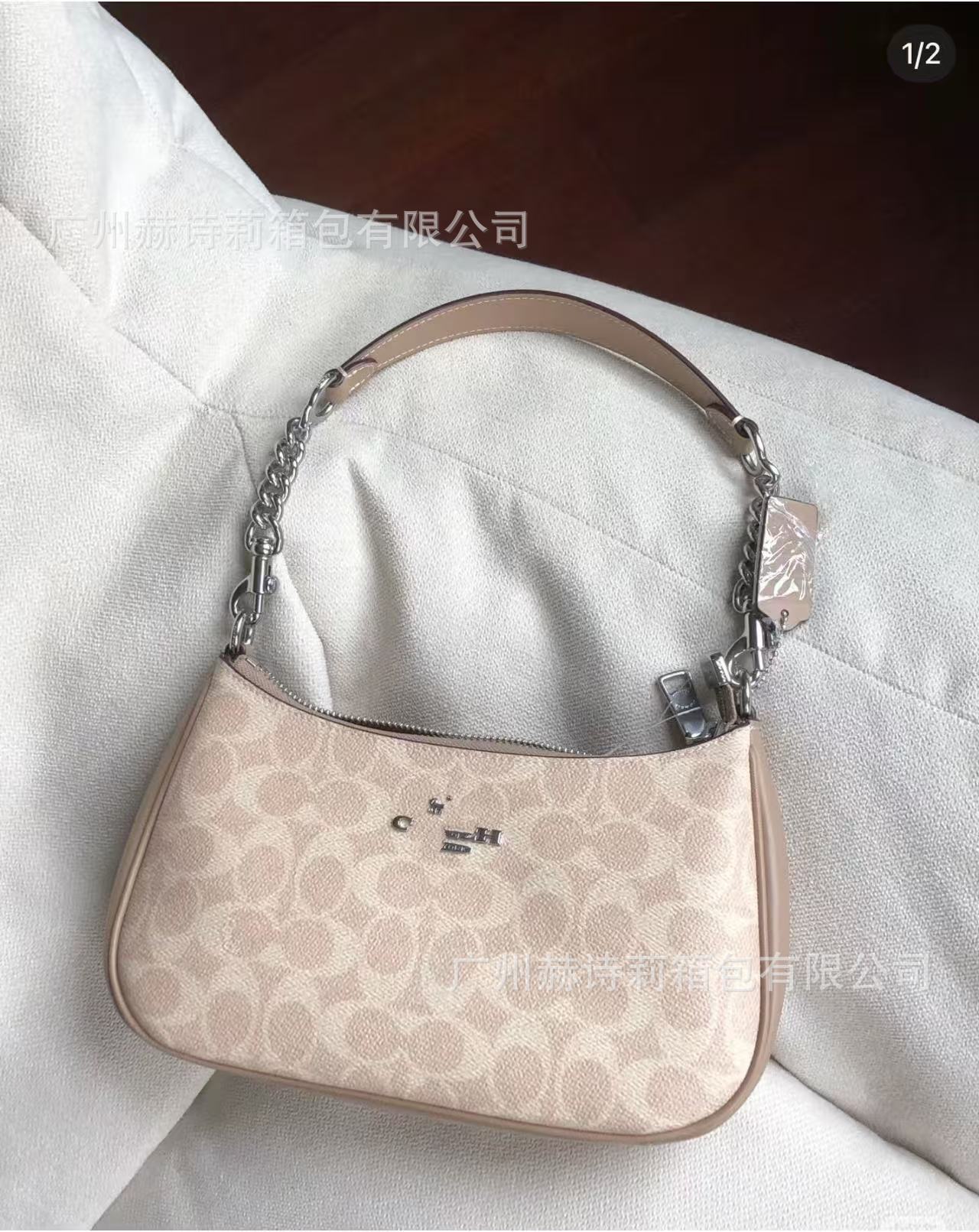 Beige handbag with chain detail on a white surface