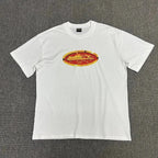White t-shirt with a colorful graphic on a gray background