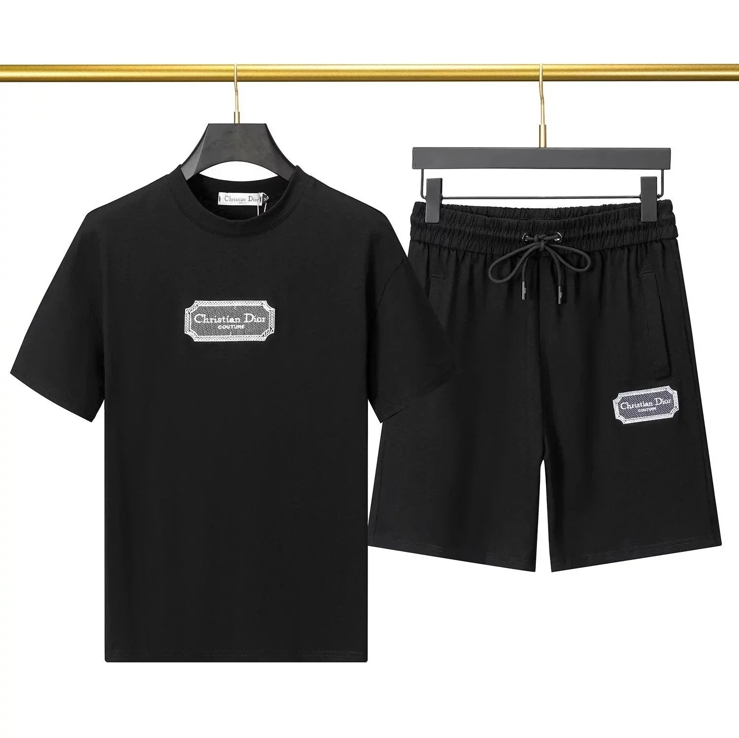 Black t-shirt and shorts set with logo on a hanger against a neutral background