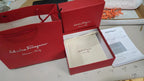 Red jewelry box with a gold necklace on a white surface
