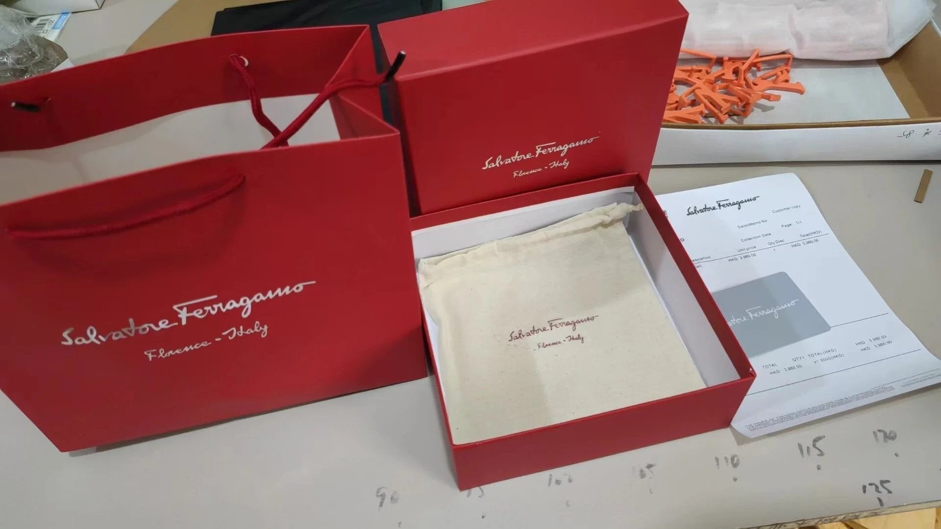 Red jewelry box with a gold necklace on a white surface