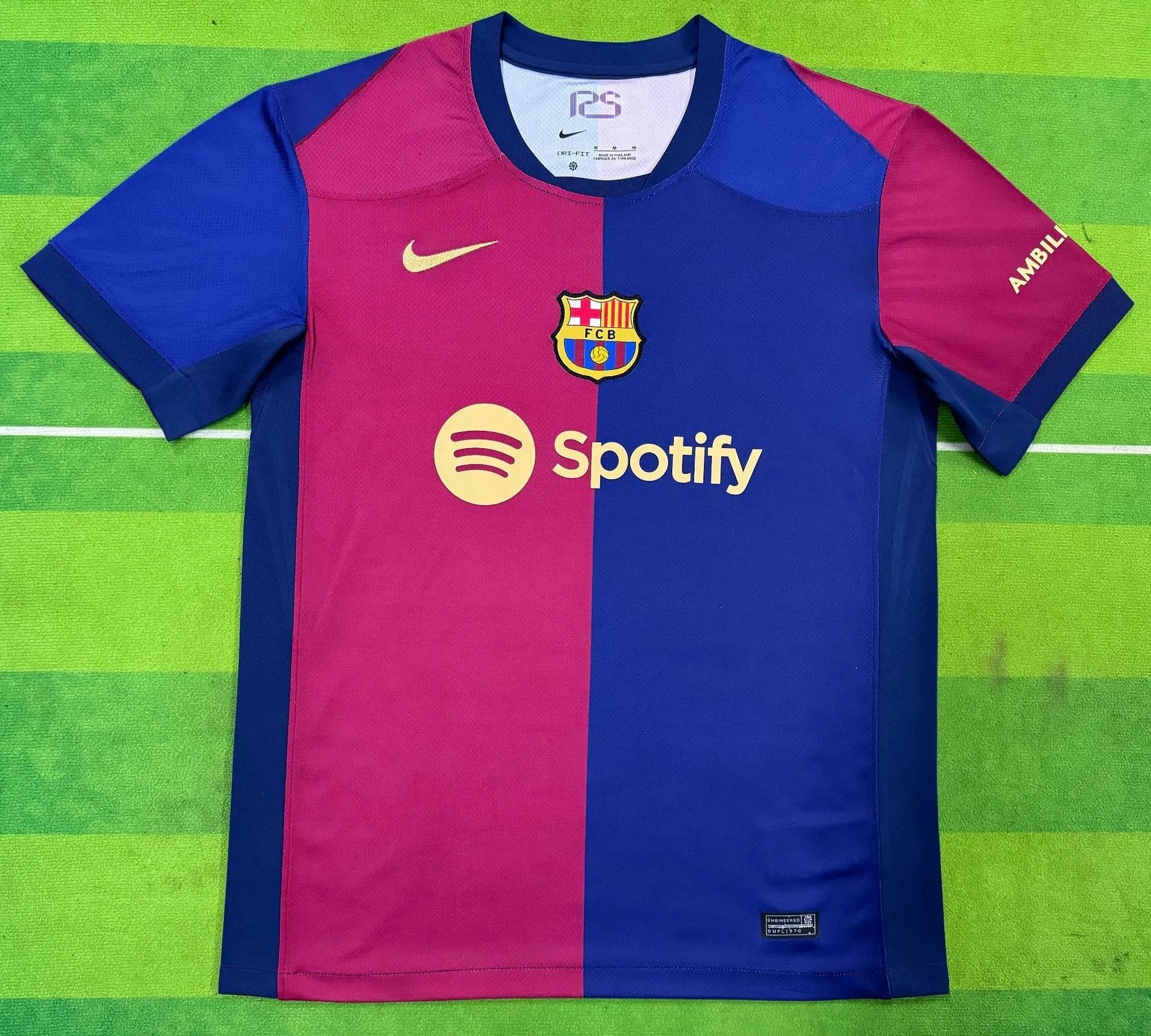 Half blue and half pink sports jersey with Spotify logo on a green field background