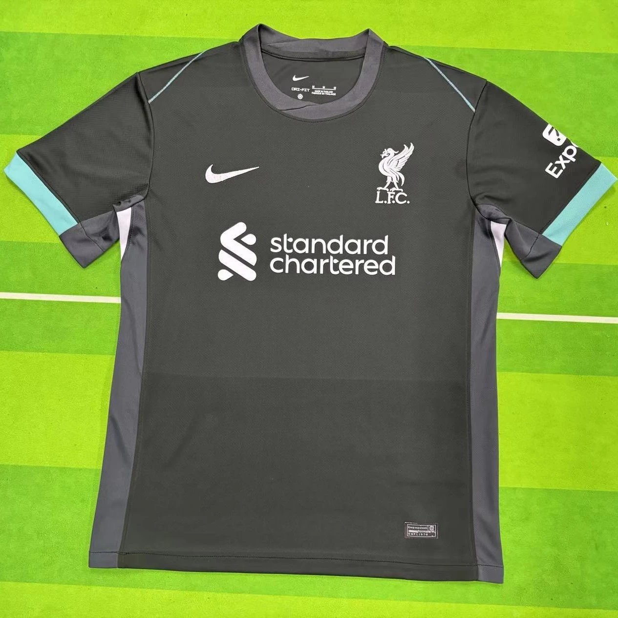Gray sports jersey with Nike and Liverpool FC logos on a green background