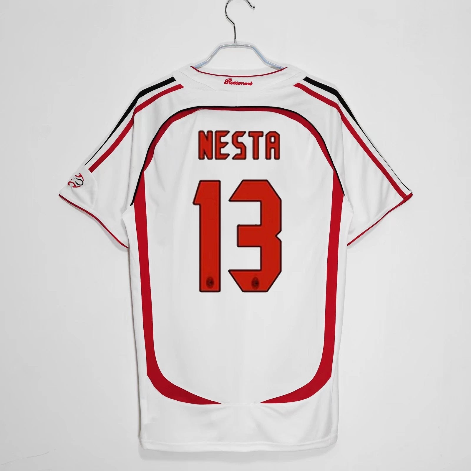 White sports jersey with red accents and 'Nesta 13' printed on a white background