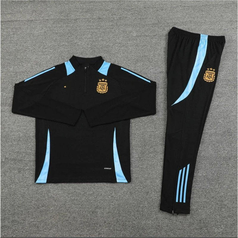 Black tracksuit with blue accents and logos on a gray background