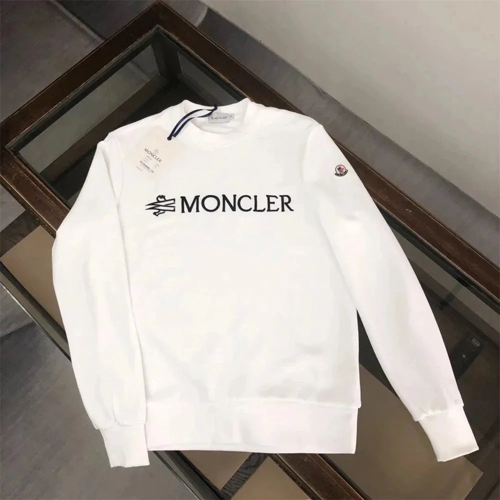 White sweatshirt with 'Moncler' logo on a dark background