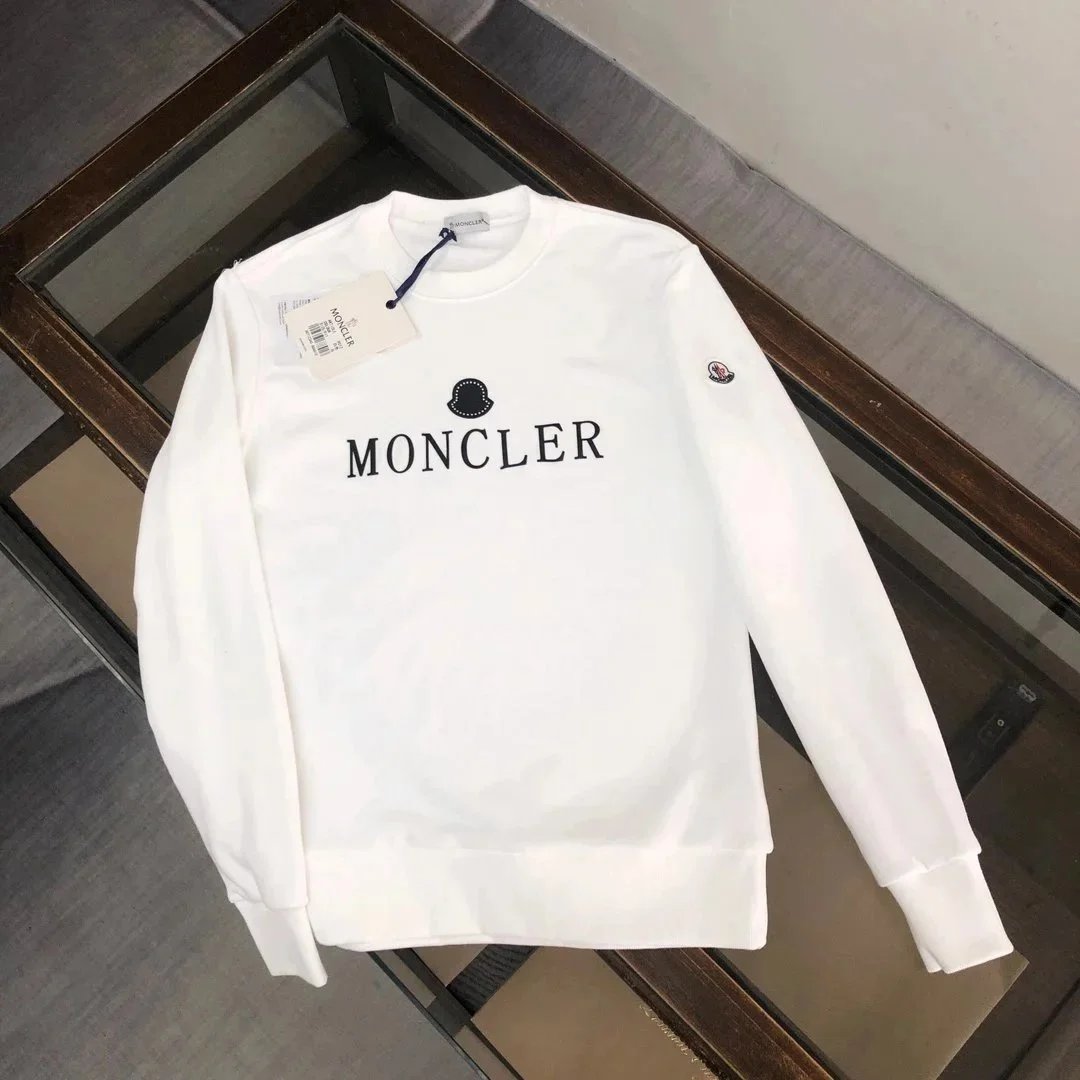 White sweatshirt with 'Moncler' branding on a reflective surface