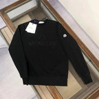 Black sweater with branding on a wooden surface