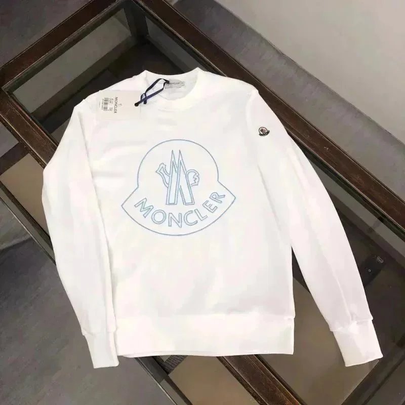 White sweatshirt with a logo on a wooden surface