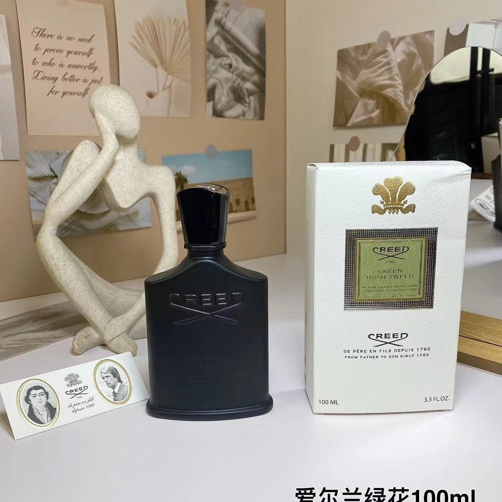 Creed perfume bottle and packaging on a table with decorative background