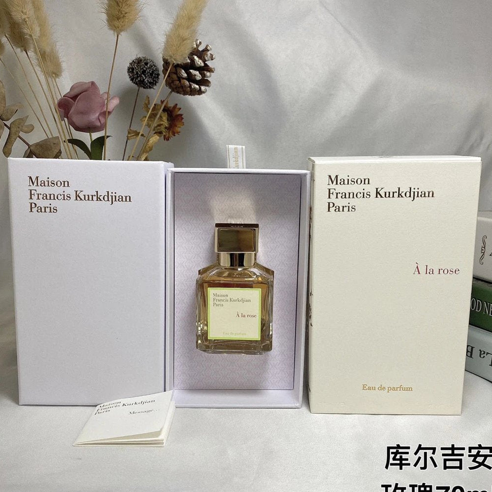 Maison Francis Kurkdjian perfume bottle in packaging with flowers and a white background