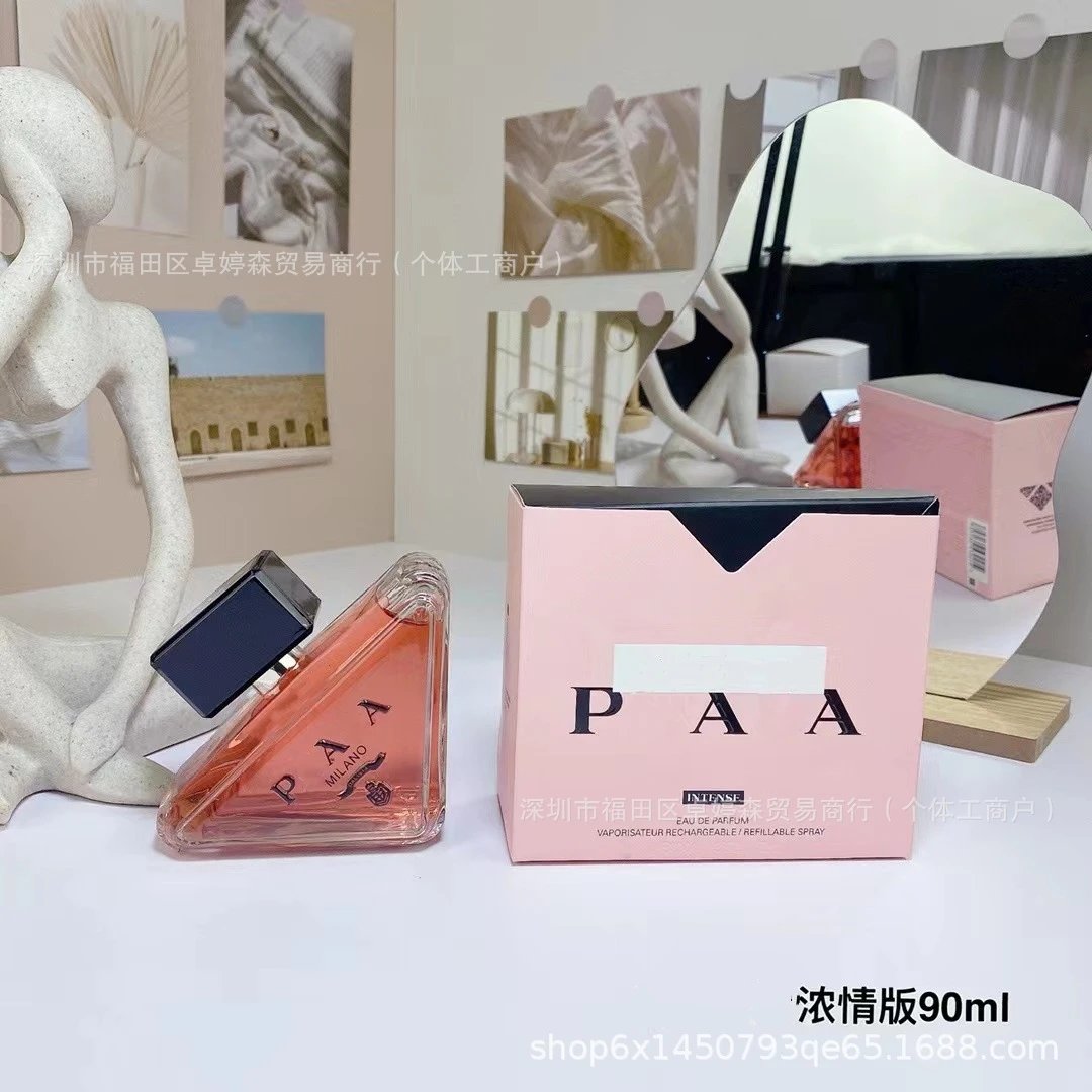 PAA perfume bottle and packaging on a white surface with decorative elements.