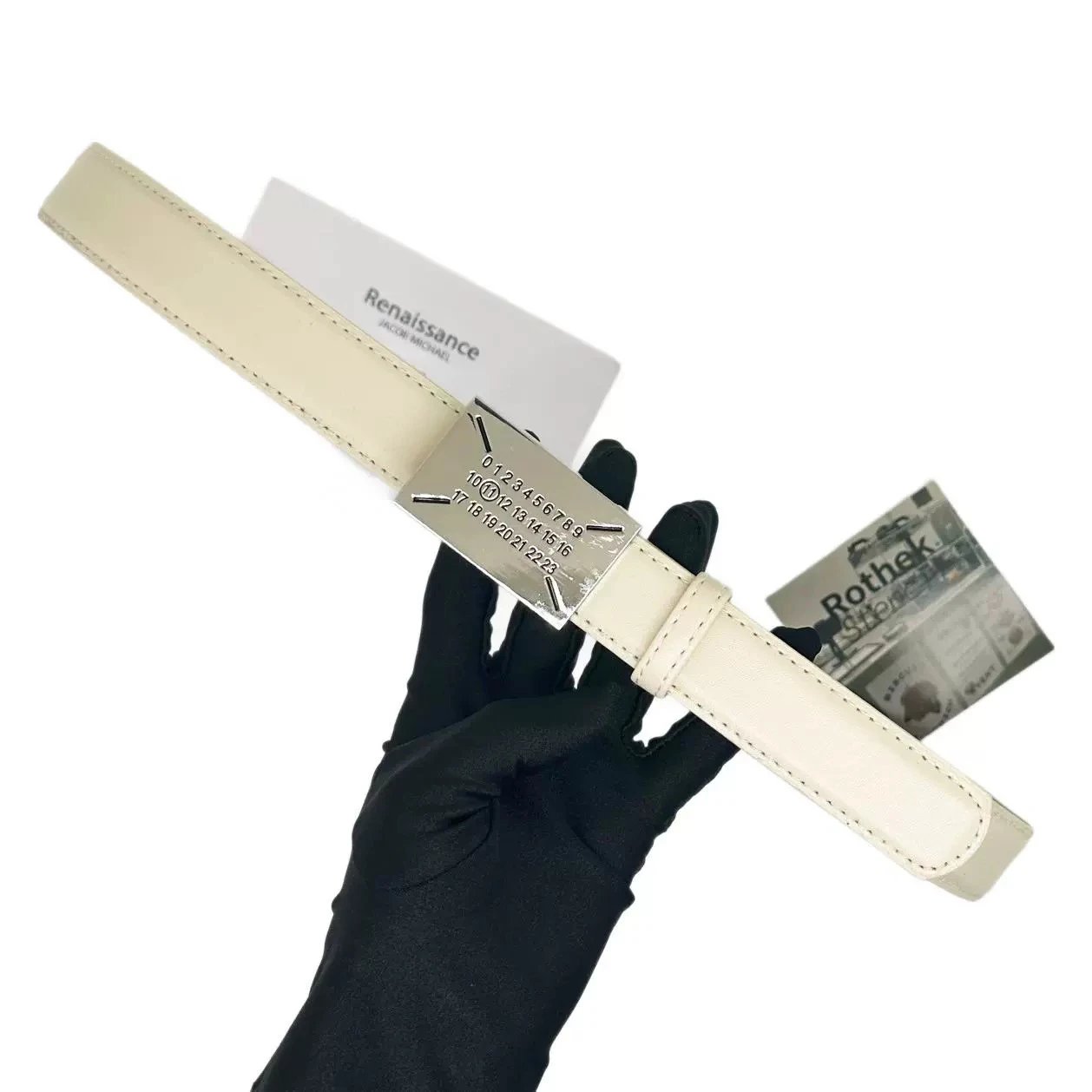White belt with silver buckle held by a gloved hand, with 'Rothschild' branding visible.