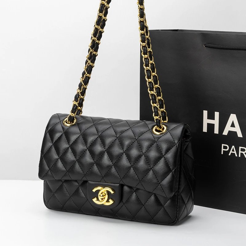 Black quilted handbag with gold chain strap in front of a black Chanel bag.