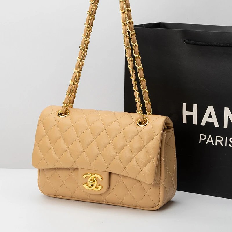 Beige quilted handbag with gold chain and clasp next to a black Chanel bag