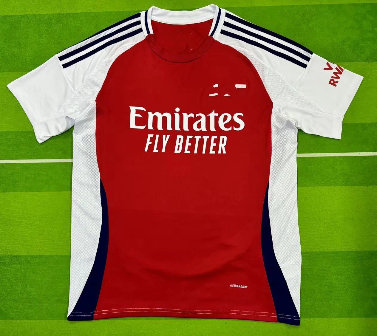 Red sports jersey with Emirates branding on a green background